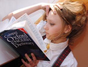 Apprendre l’anglais à l’étranger : fille lisant un dictionnaire
